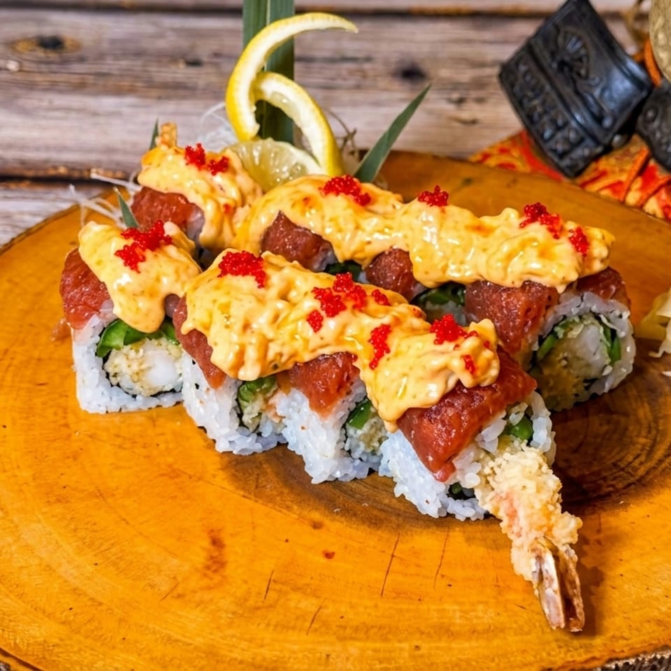 Sushi rolls with tuna, spicy sauce, and red tobiko, served with wasabi and ginger.